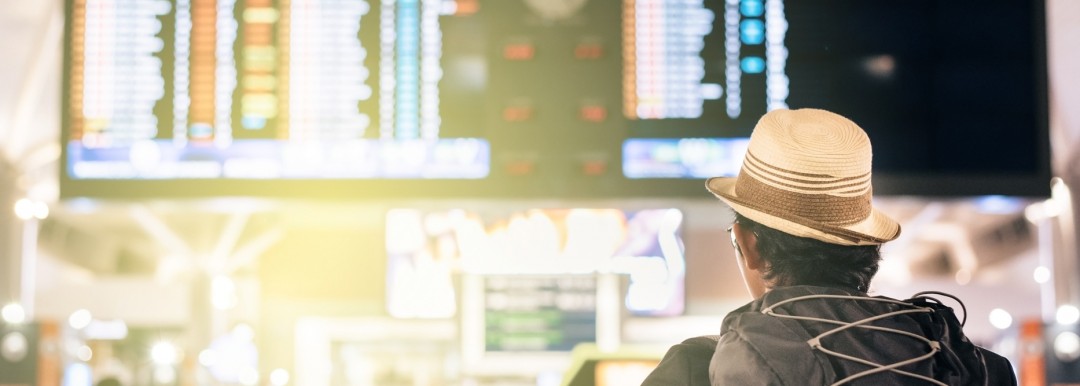 man looking at flight information screens